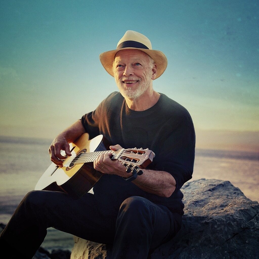 David Gilmour Playing Guitar on a Rock